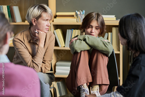 Cuadro en lienzo Adult woman facilitating group therapy session with teenage girl sitting with kn