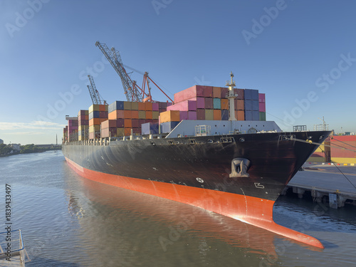 container cargo freight ship moored in port. cranes lift and move containers for loading and unloading. Modern logistics, container transport, maritime shipping, global trade and freight handling.