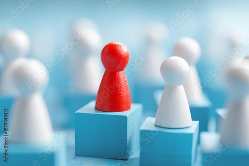 Red leader figurine elevated among white pawns on blue blocks--symbol of leadership