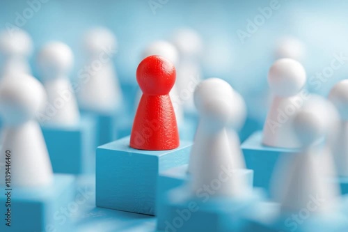 Red leader figurine elevated among white pawns on blue blocks--symbol of leadership