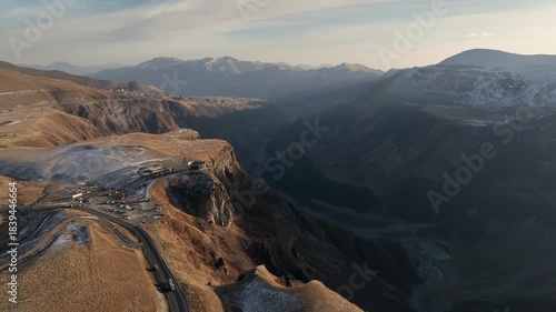 Aerial view of the historic Russia-Georgia Friendship Arch monument situated on a cliff edge near Jvari Pass in the Gudauri mountain area. Early wiinter landscape with beautiful mountains.