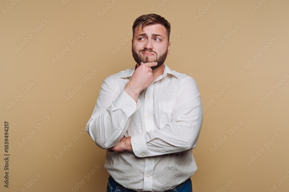 Fototapeta premium Man in white shirt pondering against beige background