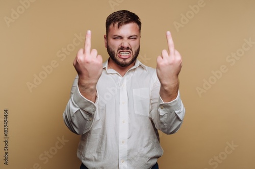 Man in white shirt making rude gestures with both hands.