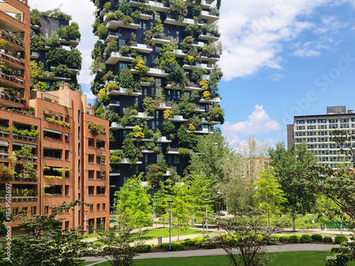 Milan, Italy – May 23, 2025: Modern residential towers of the Bosco Verticale complex rise above a landscaped urban park in the Porta Nuova district