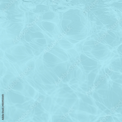 Soft blue water surface texture with natural light reflections creating abstract wave patterns.