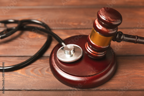 A stethoscope and hammer on a desk. Medical malpractice, personal injury lawyer, and healthcare legal aspects concept.Lawyer.Legal definition of medical negligence. Law concept.Healthcare and Medicine
