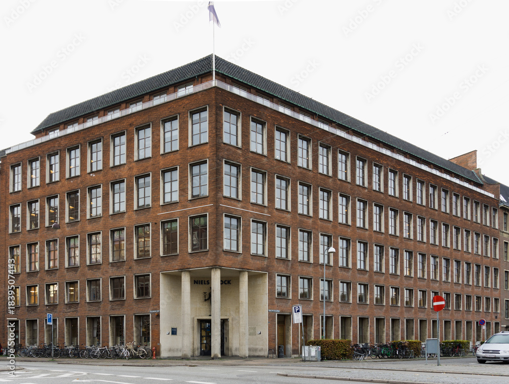 Naklejka premium COPENHAGEN, DENMARK - NOVEMBER 01, 2019: Historic Niels Brock Business College Red Brick Facade and Mercury Statue