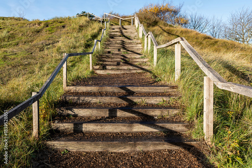 wooden stairway with railing leading upwards