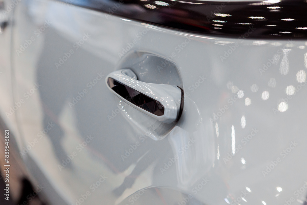 Obraz premium The handle of a modern car is white in color