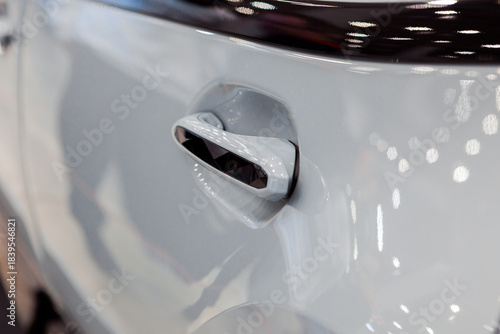 The handle of a modern car is white in color