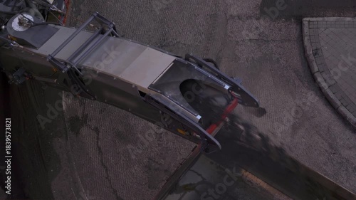 Top down view of heavy machinery paving a road with hot asphalt during reconstruction work