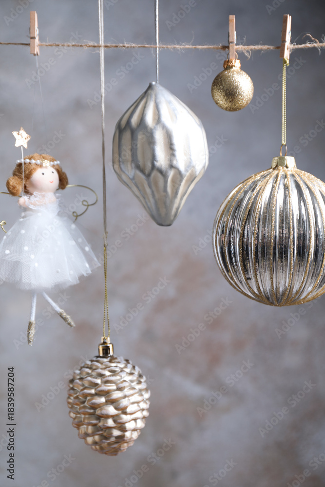 Naklejka premium Beautiful Christmas decor hanging on string near light grey wall