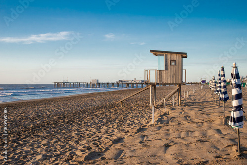 Lifeguard cabin on a beach landscape at sunrise with blue sky and sea. Pinamar, Argentina