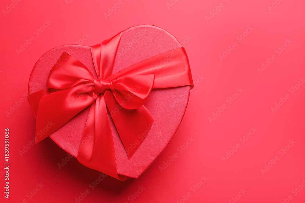 Fototapeta premium Happy Valentine's Day. Heart shaped gift box on red background, top view. Space for text