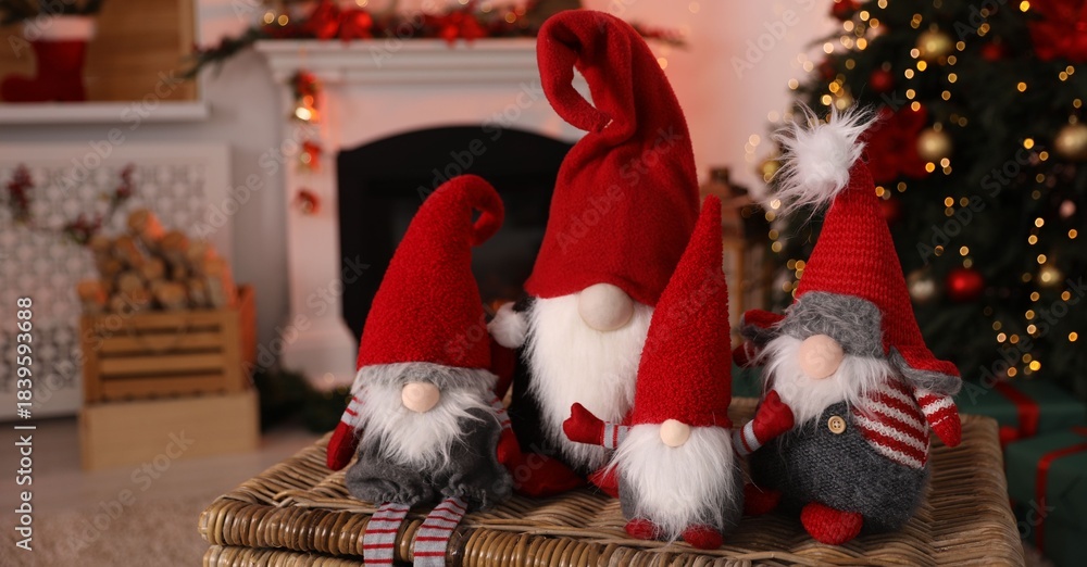 Obraz premium Cute Christmas gnomes on wicker box against blurred lights indoors, closeup. Space for text