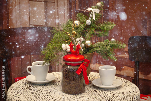 Christmas table with two cups of coffee, holiday decor, Christmas tree branch and coffee jar with red lid. Vintage Christmas