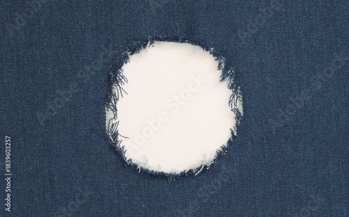 Grunge blue canvas denim fabric with crumpled torn circle frame. Texture abstract background.