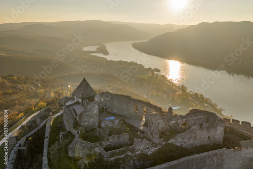 Visegrad, Hungary - Aerial panoramic drone view of the beautiful high castle of Visegrad on a moody autumn sunset. Danube Bend (Dunakanyar) and amazing golden sunset at background.
