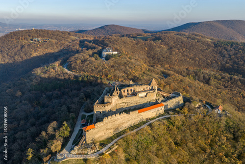 Visegrad, Hungary - Aerial panoramic drone view of the beautiful high castle of Visegrad on a moody autumn sunset. Danube Bend (Dunakanyar) and amazing golden sunset at background.