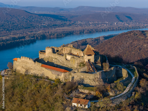 Visegrad, Hungary - Aerial panoramic drone view of the beautiful high castle of Visegrad on a moody autumn sunset. Danube Bend (Dunakanyar) and amazing golden sunset at background.