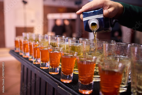 Vibrant party beverages, Festive setup with lively drink arrangements and busy bartenders, Array of layered shots and colorful cocktails ready for spirited gathering