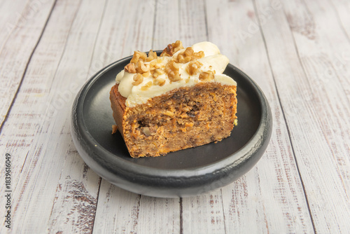Quadro em tela Carrot cake with walnuts and raisins, topped with a generous cream cheese frosti
