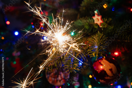 ozdoby, symbole bożonarodzeniowe w kolorowym jaskrawym świetle na tle choinki