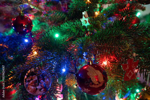 ozdoby, symbole bożonarodzeniowe w kolorowym jaskrawym świetle na tle choinki