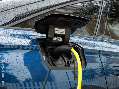 EV electric car plugged in as it is being charged, UK