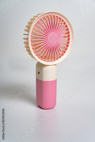 A small hand-held fan for personal use. On white background.