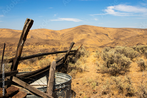 Foto A view of a desert landscape that had recently been burned by a wildfire with a fence and empty water trough