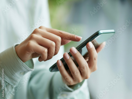 スマホを操作する女性の手元　A close-up of a woman's hands operating a smartphone　Generative AI