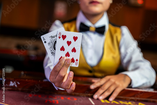 Dealer showing ace and eight cards at a baccarat table, capturing gaming action, professional service, and the vibrant atmosphere of a modern casino.