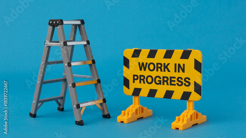 Miniature step ladder and 'Work in Progress' sign on solid turquoise background representing ongoing project