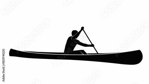 Silhouette of a person paddling a long canoe boat.