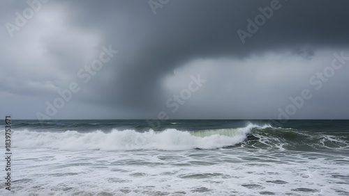 Fototapeta Naklejka Na Ścianę i Meble -  Powerful ocean wave cresting dramatically under a heavy ominous dark gray stormy sky at sea