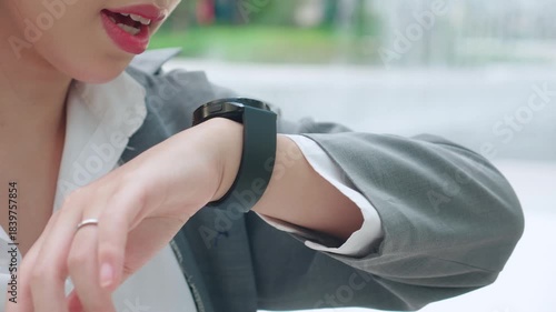 Young asian businesswoman using voice recording or speech recognition technology in smartwatch for voice command with AI, business woman talking to mic and recorder of smartwatch, virtual assistant.