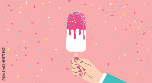 Woman's hand holding a delicious ice cream popsicle with pink dripping glaze and colorful sprinkles against a sweet pink background.