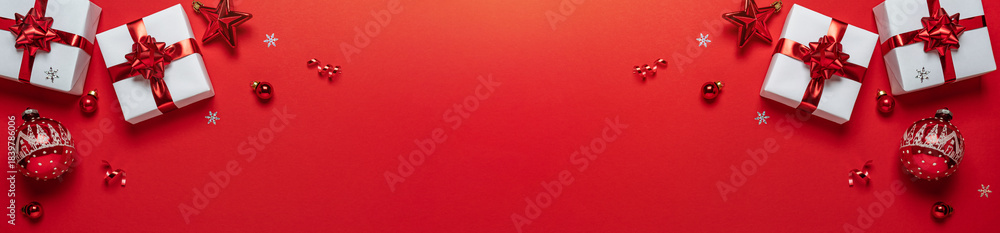 Fototapeta premium Christmas gifts with red glitter decorations on red background with bokeh. Merry Christmas and Happy New Year greeting card. Xmas and Winter holidays. Christmas wide banner, top view