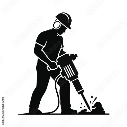 Silhouette of construction worker using jackhammer on ground.