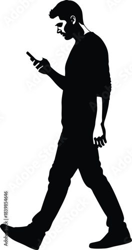 Silhouette of a man walking while using a mobile phone