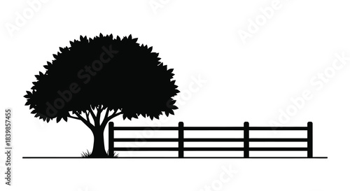 A striking scene of a tree and wooden fence presented in a stark black silhouette
