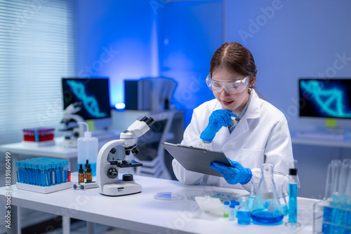 Scientist taking notes while examining samples in laboratory