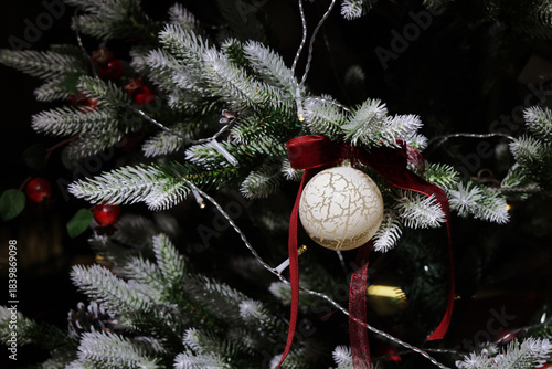A white Christmas ball on a Christmas tree.