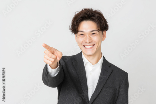 笑顔で指差す若いビジネスマン