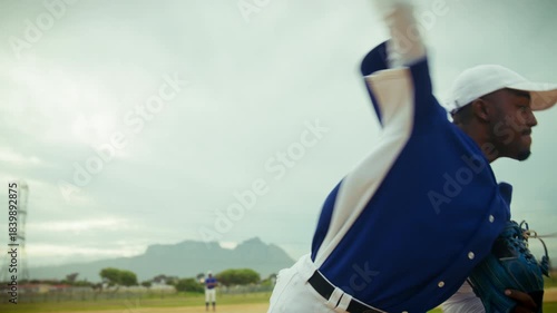 A focused baseball pitcher winds up and throws a fastball on the mound, demonstrating athletic skill and dedication during the game.