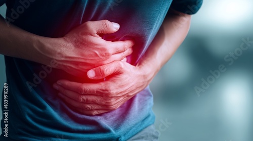 Close up of man experiencing abdominal pain and cramp with hands on stomach
