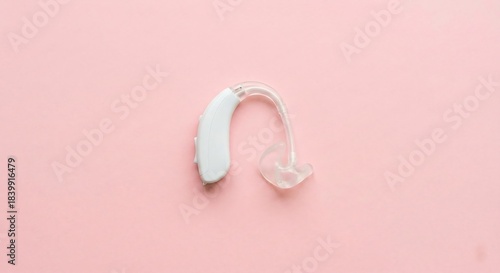 Single Hearing Aid on Pastel Pink Background in Minimal Flat-Lay Style