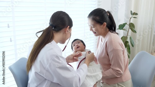 Asian mother with little baby daughter visiting pediatrician in clinic, hospital, healthcare and pediatrics concept.