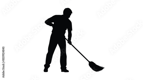 Silhouette of a man sweeping floor with a broom